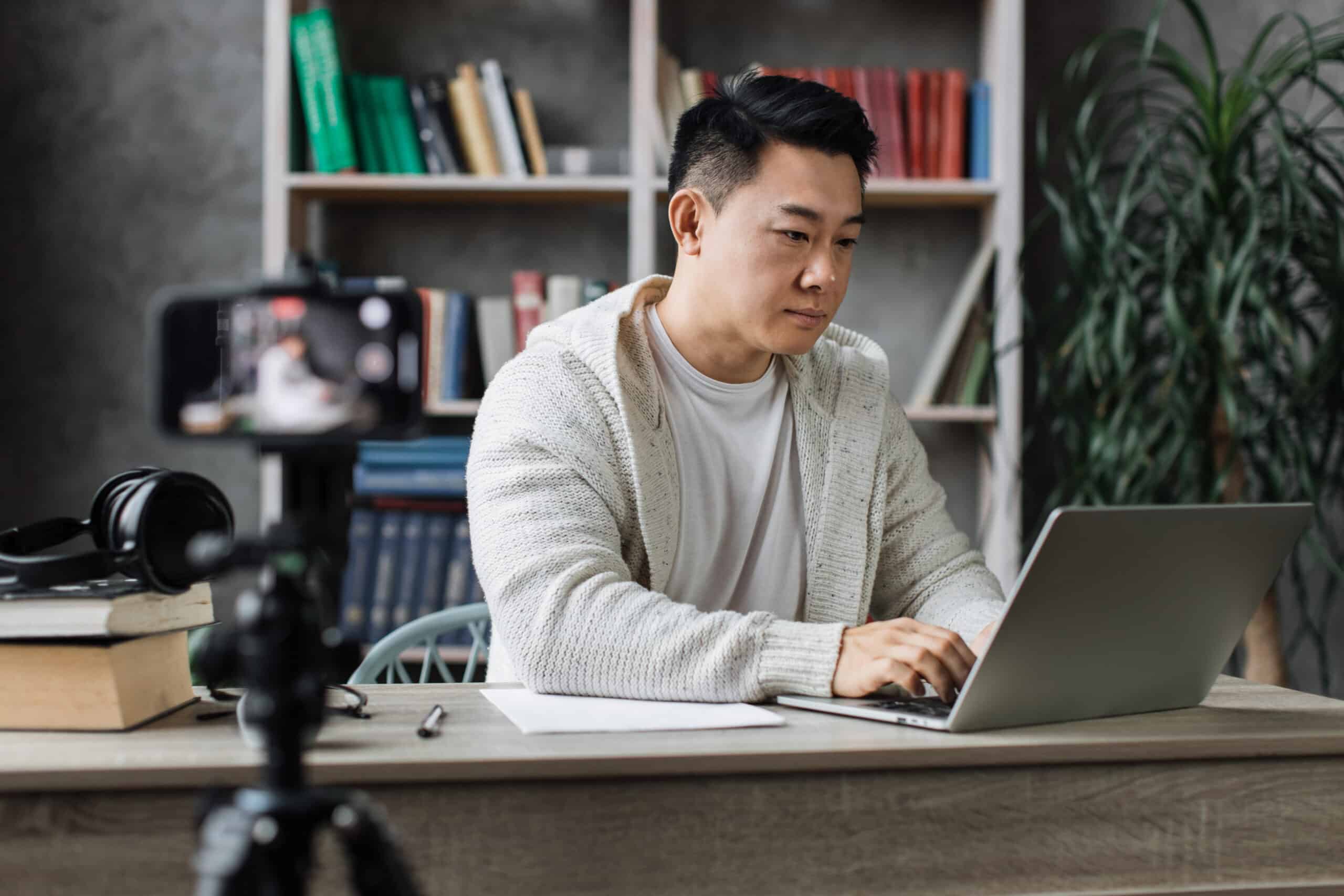 attractive-asian-male-working-on-laptop-and-record
